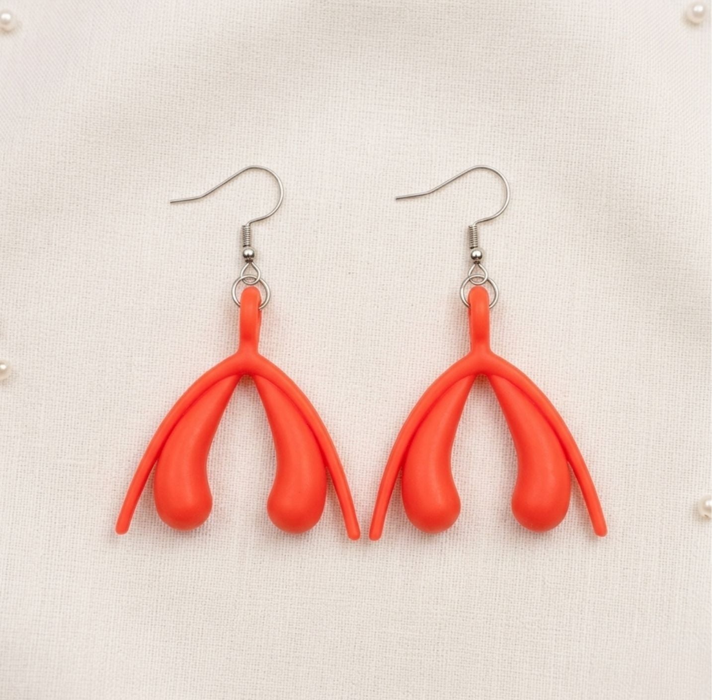 Kl*toris Ohrringe aus Acryl am Ohr getragen – feministische Statement-Earrings von Bling Bling Feministas - rot