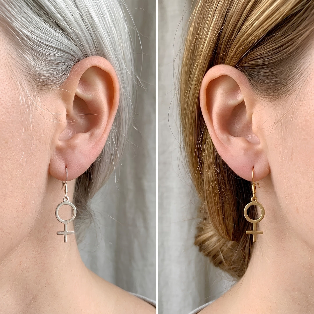 Venus Symbol Ohrringe in Silber – Paar feministische Edelstahl-Hänger mit ♀-Symbol in einer Hand von Bling Bling Feministas