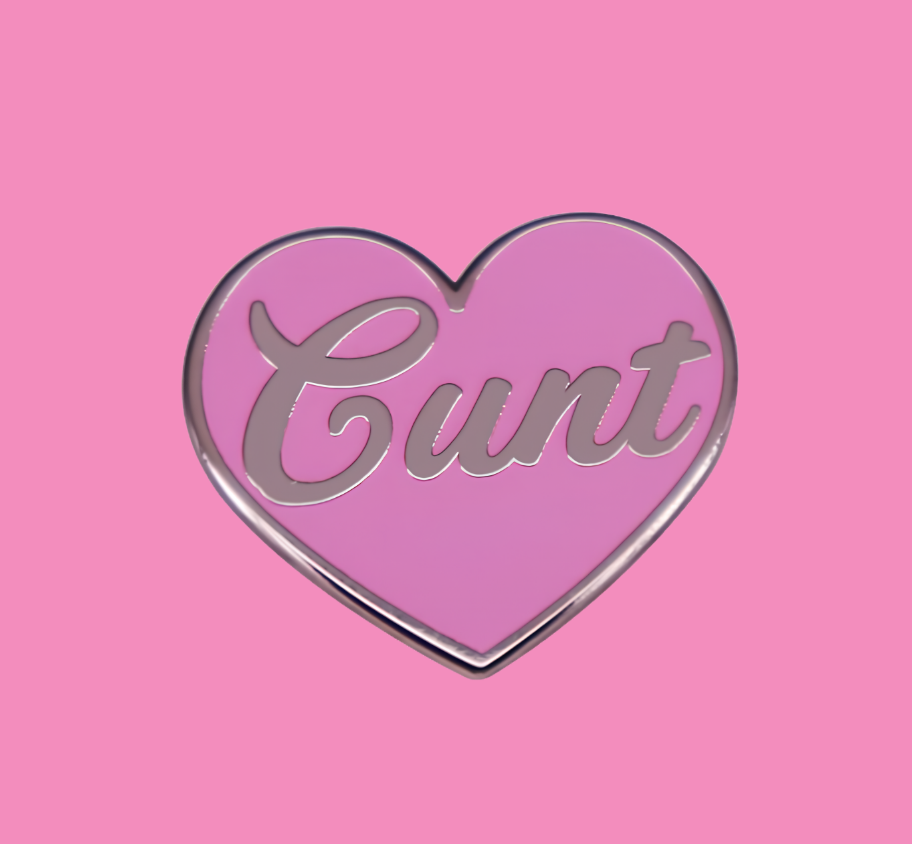 Cu*nt Ansteckpin in Pink auf Jeansstoff – herzförmiger Emaille-Pin mit Schriftzug von Bling Bling Feministas