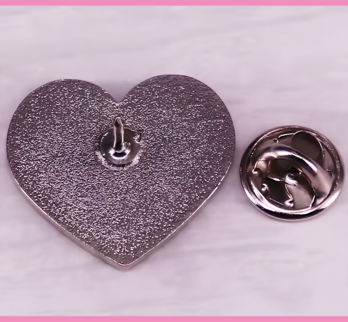 Cu*nt Ansteckpin in Pink auf Jeansstoff – herzförmiger Emaille-Pin mit Schriftzug von Bling Bling Feministas