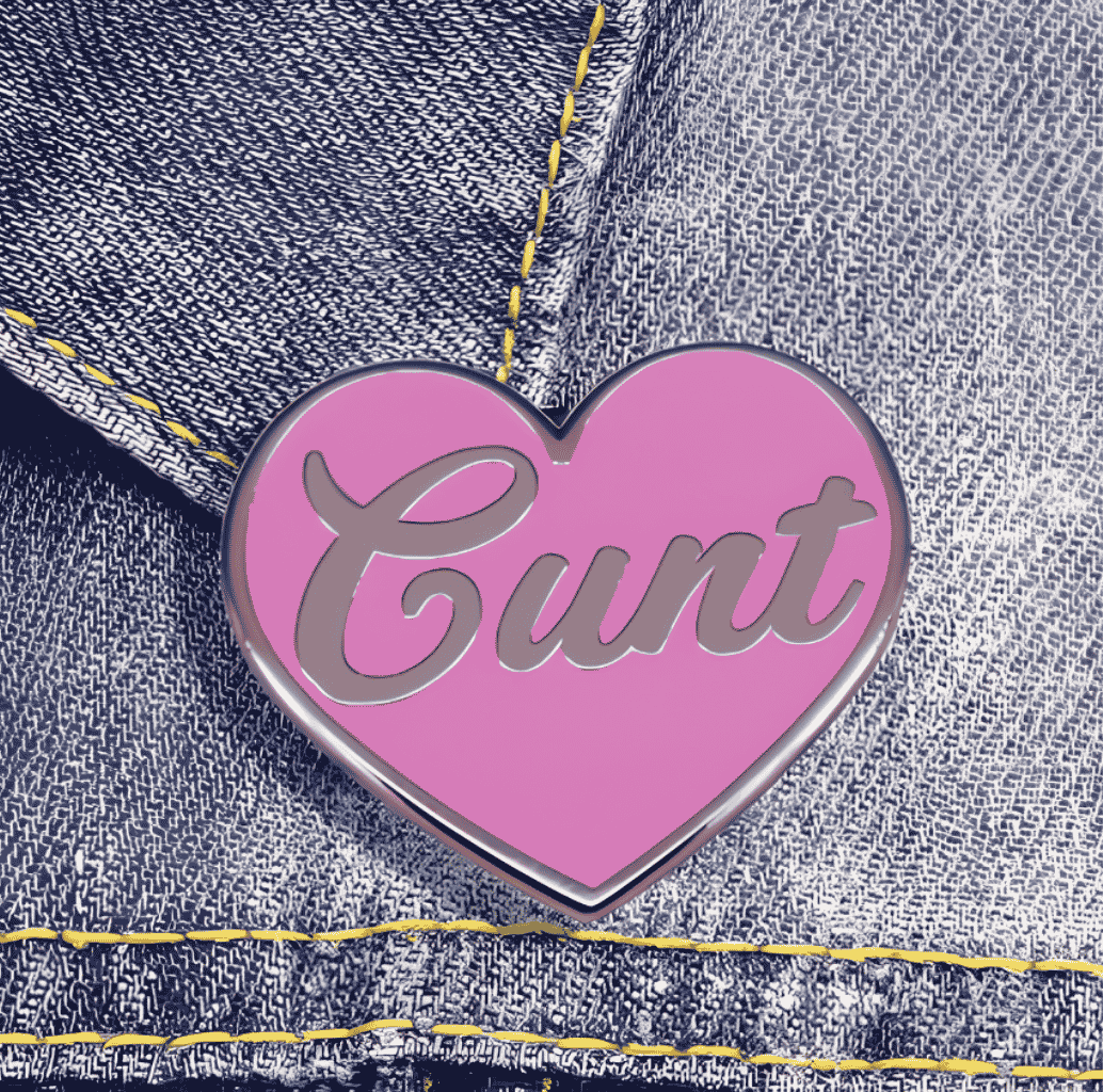 Cu*nt Ansteckpin in Pink auf Jeansstoff – herzförmiger Emaille-Pin mit Schriftzug von Bling Bling Feministas