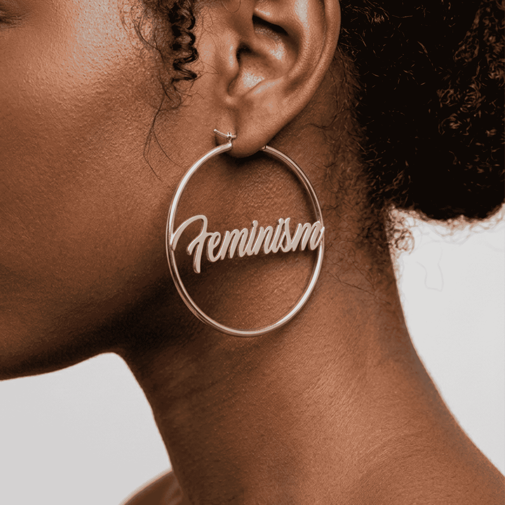 Silberne Feminism Creole 60mm am Ohr getragen – großer Edelstahl-Ohrring mit Schriftzug von Bling Bling Feministas