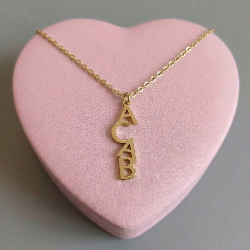 ACAB 1312 Halskette in Gold – Edelstahlkette mit senkrechtem ACAB-Buchstabenanhänger auf rosa Herz-Deko, Bling Bling Feministas