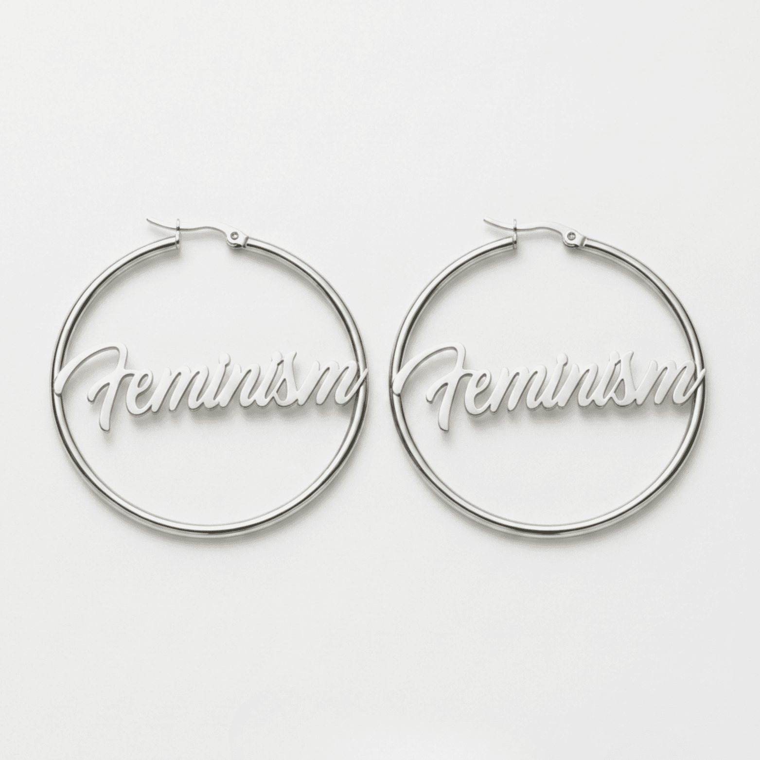 Silberne Feminism Creole 60mm am Ohr getragen – großer Edelstahl-Ohrring mit Schriftzug von Bling Bling Feministas