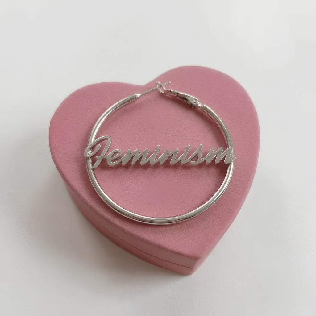 Feminism Creole in Silber aus Edelstahl mit Schriftzug Feminism in Schreibschrift auf rosa Herzschachtel