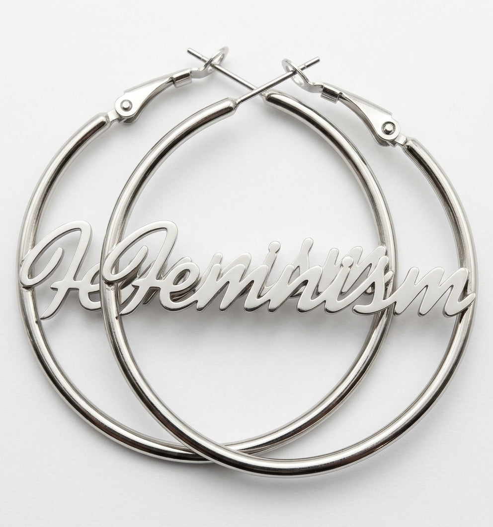 Paar Feminism Creolen in Silber aus Edelstahl mit Schriftzug Feminism, überlappend vor weißem Hintergrund