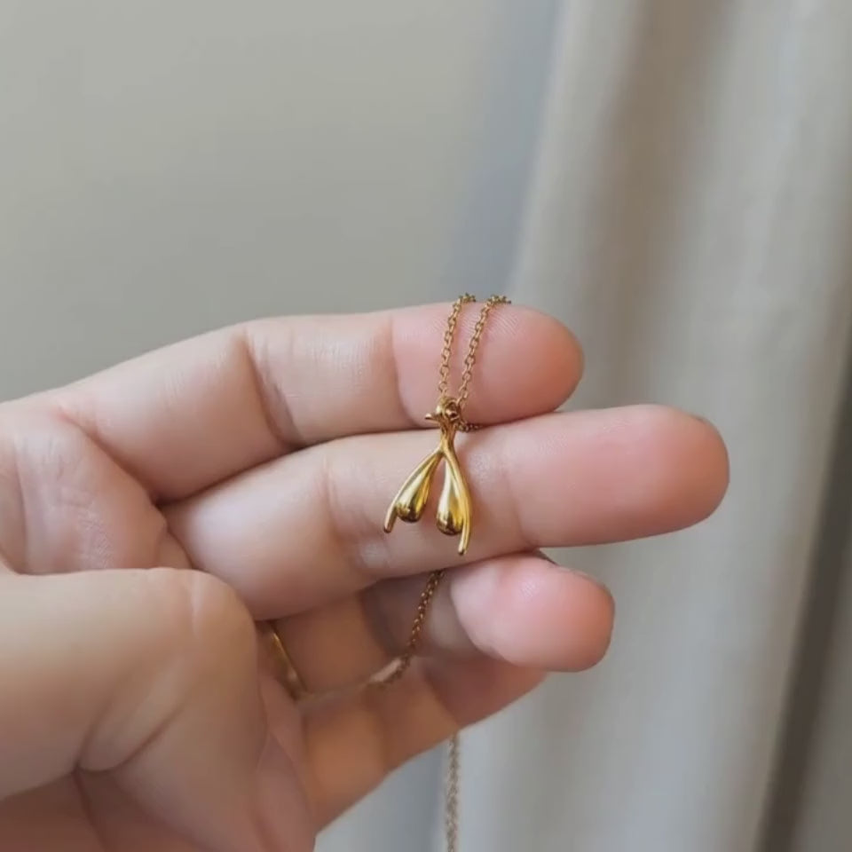 Produktvideo: Klitoris Halskette Gold – anatomischer Anhänger aus vergoldetem Edelstahl auf weißem Stoff