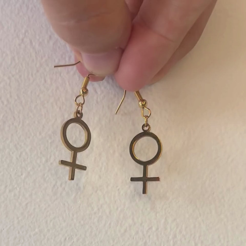 Venus Symbol Ohrringe in Gold – Paar feministische Edelstahl-Hänger mit ♀-Symbol in einer Hand von Bling Bling Feministas
