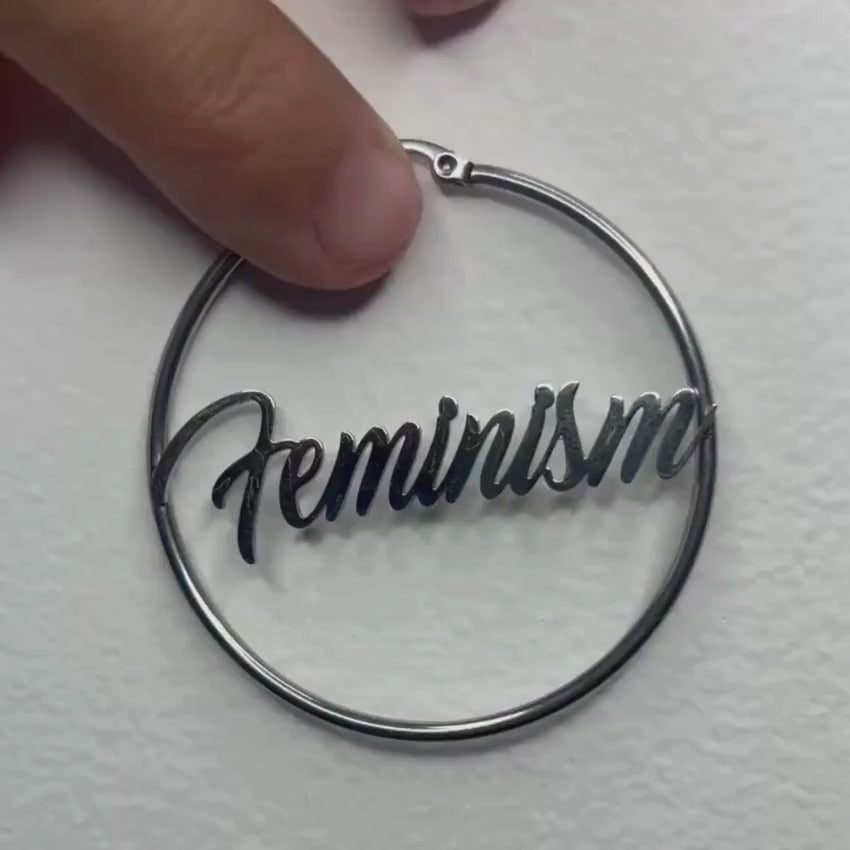 Produktvideo: Silberne Feminism Creole 60mm am Ohr getragen – großer Edelstahl-Ohrring mit Schriftzug von Bling Bling Feministas