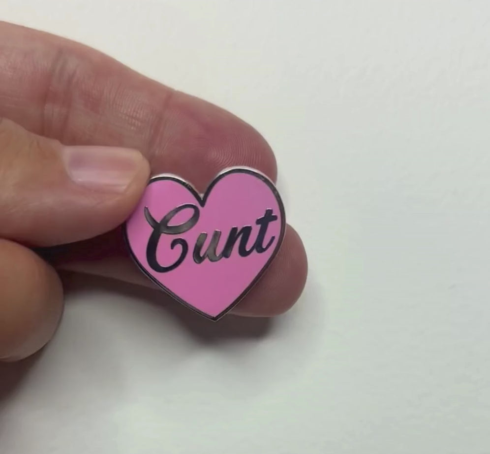 Cu*nt Ansteckpin in Pink auf Jeansstoff – herzförmiger Emaille-Pin mit Schriftzug von Bling Bling Feministas